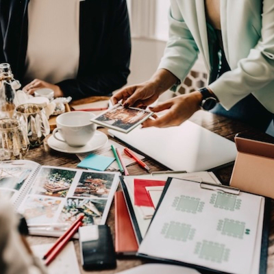 A diverse team gathered around a tablet, excitedly exploring event options and discussing ideas in a modern, vibrant setting.